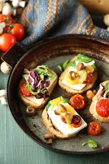 Tasty sandwiches on old pan, on wooden table