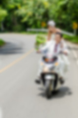 Blurry background, Just married. Groom and bride on the motorcyc