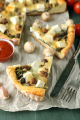 Cheese pie with mushrooms, herbs and sour creme, on napkin, on wooden table background
