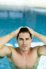 Man touching his hair in the swimming pool