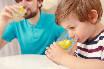 Father and son drink lemonade