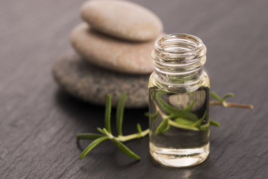 Essential oil with rosemary and fresh green leaves