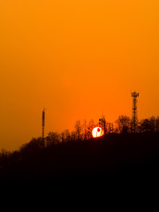 Sunset over urban mountain on orange sky