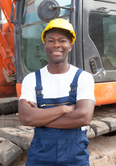 Afrikanischer Bauarbeiter vor seinem Bagger