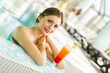 Beautiful woman in a pool with a cocktail