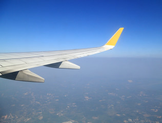 Obraz premium Wing of an airplane flying above sky