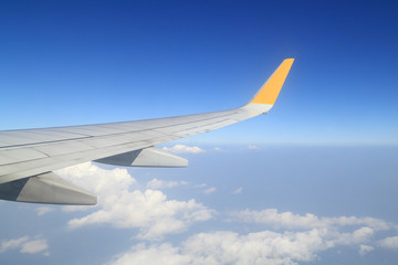 Wing of an airplane flying above sky