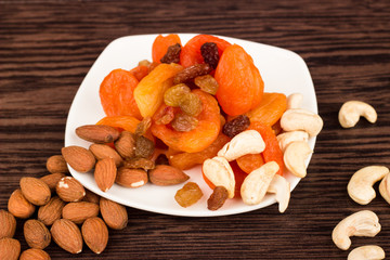 Snacks of nuts and dried fruits on a wooden surface