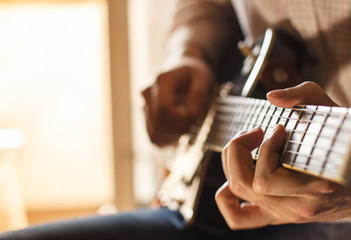 Practicing in playing guitar. Handsome young men playing guitar