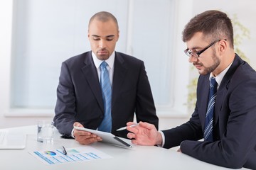 Business. Image of two young businessmen discussing project at