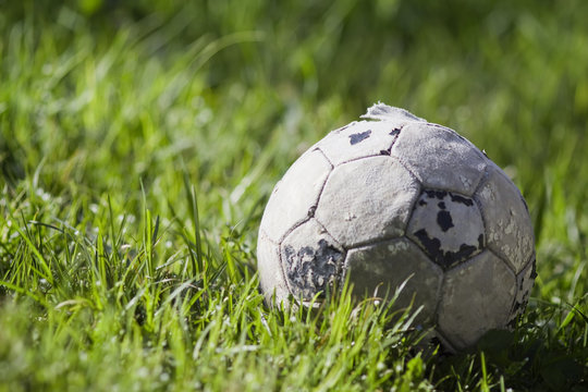 Old soccer ball on the grass