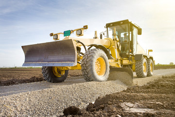 Grader working on gravel leveling