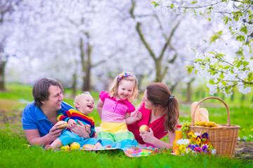 Young family with kids having picnic outdoors