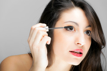Portrait of a beautiful woman applying makeup