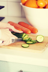 Woman slicing cucumber