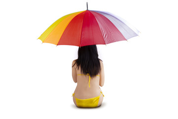 Woman sitting under colorful umbrella