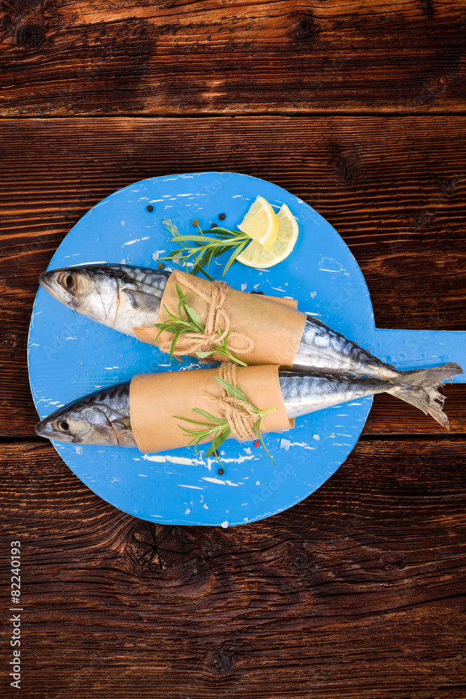 Poster delicious fresh mackerel fish on wooden kitchen board.