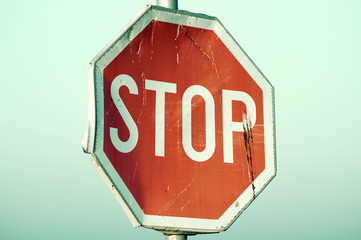 Old rusty stop sign in retro pastel colors