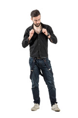 Fototapeta premium Young man buttoning shirt isolated