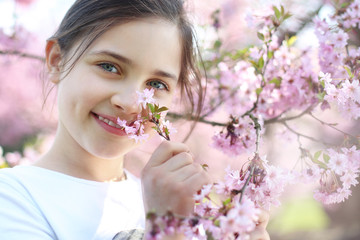 Naturalne piękno. Portret dziewczynki w kwiatach wiśni.