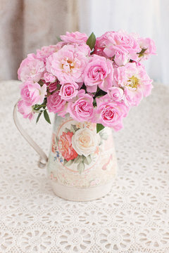 Beautiful fresh pink roses on a table. light background.