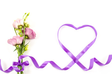 Heart shaped ribbon with flower on white background