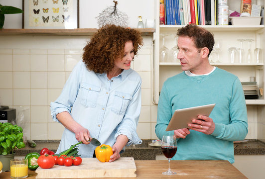 Husband and wife reading recipe from tablet