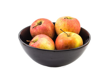 four apple in black bowl still life on white background