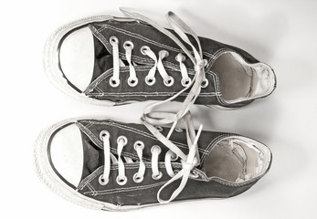 A pair of black canvas sneakers on white background