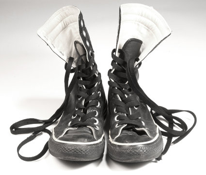 A pair of black canvas sneakers on white background
