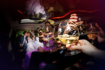 Happy groom and the bride in the car together with  friends - obrazy, fototapety, plakaty