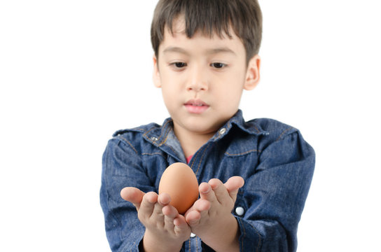 Little boy holding egg in hand healthy focus on egg on white bac