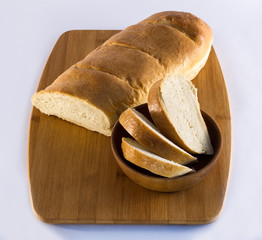 French Bread Loaf on Cutting Board with Sliced Bread in Bowl