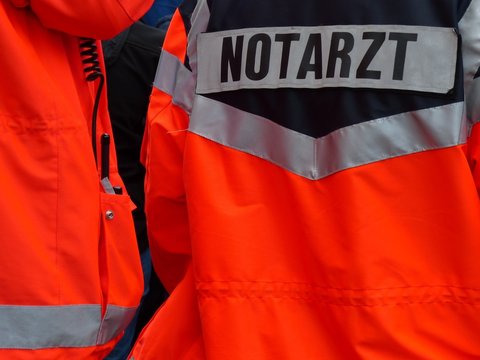 Notarzt und Rettungssanit&auml;ter mit wetterfesten Jacken in Orange beim Hermannslauf in Oerlinghausen bei Bielefeld im Teutoburger Wald in Ostwestfalen-Lippe