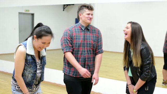 A group of young friends (dancers) laugh - hall