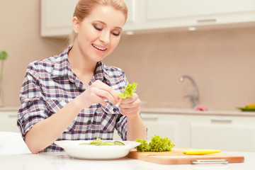 Woman makes salad of fresh vegetables