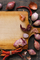 Wooden board with onions, garlic and pepper background