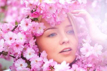 spring outdoor portrait of a charming girl in flowers bloom