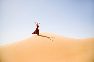 Brown dressed woman enjoys the desert dunes