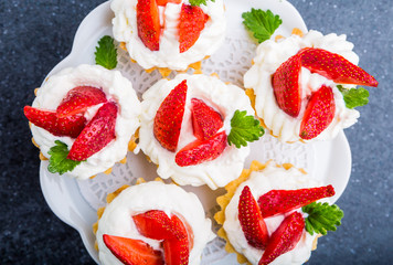 Delicious cupcake with whipped cream and fresh strawberries