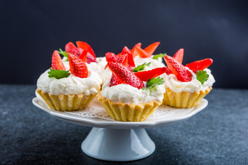 Delicious cupcake with whipped cream and fresh strawberries