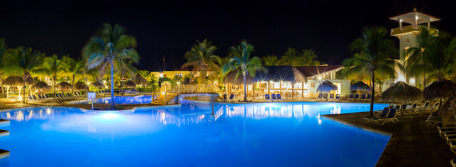Panorama of hotel and swimming pool at night,