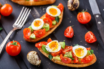 Bruschetta with tomato, avocado and quail egg