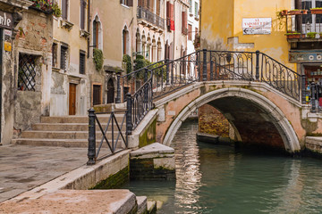 Fototapeta na wymiar Arch bridge over a narrow canal in Venice, Italy.