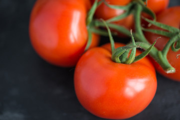 Tasty and fresh tomatoes on a black stone serving board