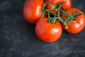 Tasty and fresh tomatoes on a black stone serving board
