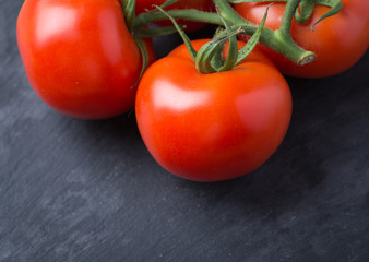 Tasty and fresh tomatoes on a black stone serving board