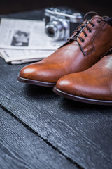 Brown leather shoes on black floor