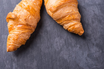 Tasty french croissant on a black stone plate