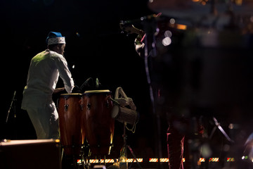 African man singing and playing ethnic drums